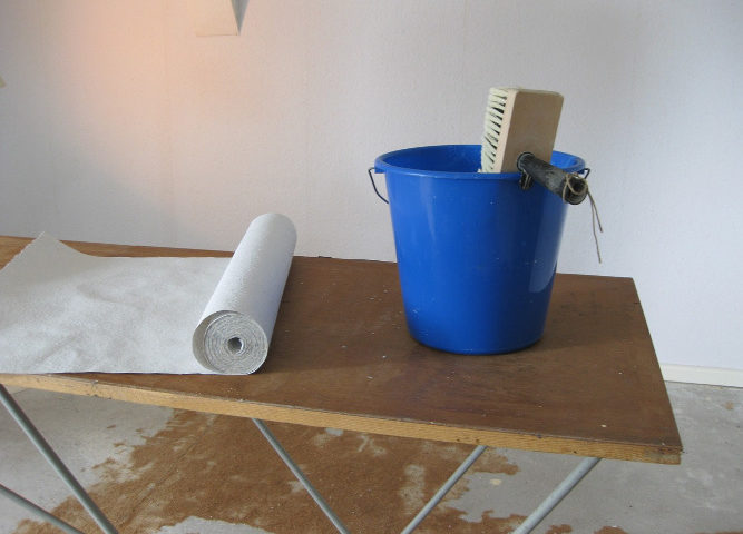 Tapeziertisch mit Tapete und Kleber