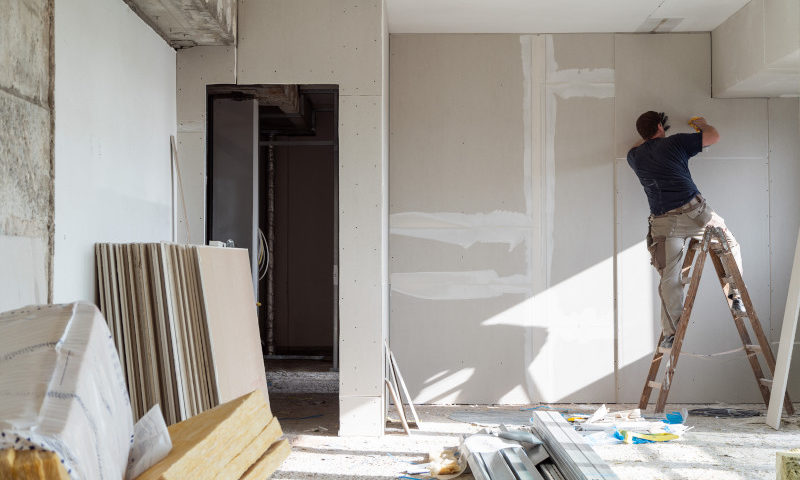 Ein Trockenbauer arbeitet auf einer Leiter in Bochum