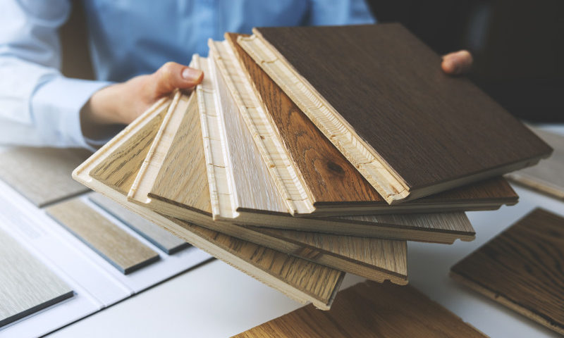 Eine Person zeigt eine Auswahl verschiedener Bodenbeläge